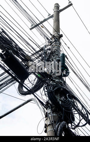 Messy street post with eletric wires and cables. Chaotic street pole in Brazil. Stock Photo