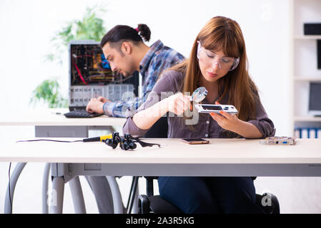 The two technicians working at computer warranty center Stock Photo