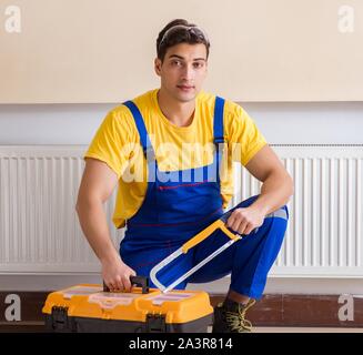 Young repairman contractor repairing heating panel Stock Photo