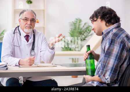 The young male alcoholic visiting old doctor Stock Photo