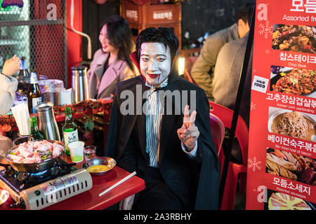 Seoul, South Korea - 27 October 2019: Man disguised as dracula eat in a street restaurant and enjoy his halloween celebration in the street of Itaewon Stock Photo