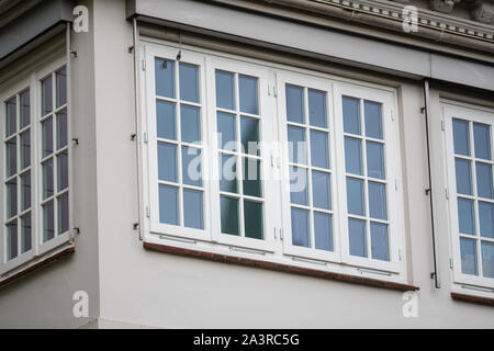 Reflecting windows  of a white house consist of small glass panes Stock Photo