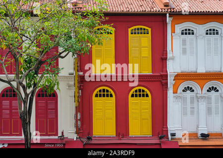 Multi-colored Chinese shophouses in Chinatown, Singapore, with their typical arched and latticed windows Stock Photo