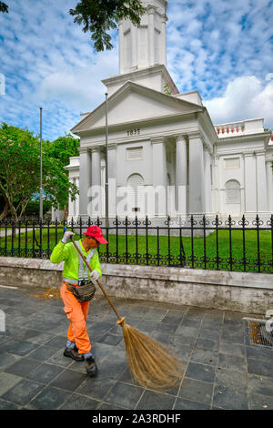 A road sweeper at work in front of the Armenian Apostolic Church of St. Gregory the Illuminator, commonly simply known as Armenian Church, Singapore Stock Photo