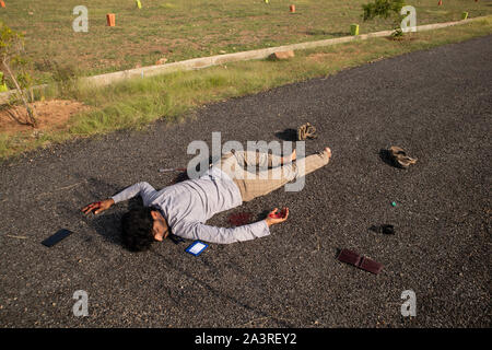 Concept of Crime scene, Wide angle shot of victim dead body laying on Road. Stock Photo