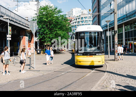 Berlin, Germany - July 27, 2019: Yellow public transportation tram passing by the city of Berlin. Sustainability concept Stock Photo