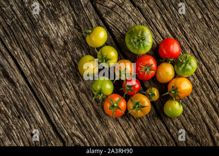 Flat-lay of fresh colorful ripe Fall or Summer heirloom tomatoes variety over rustic background, top view, copy space. Stock Photo
