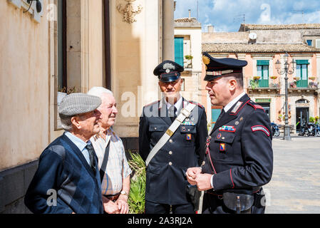 Syracuse Sicily/ Italy - october 04 2019: Carabinieri discuss with two elderly people in the town square Stock Photo