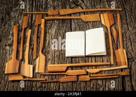 Frame made of Kitchen Utensils on a farmhouse rustic kitchen table with notebook. Stock Photo