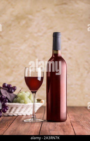 Red wine glass with bottle on stucco background and wiht clipping path. Stock Photo