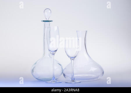 Empty decanters with wine glass and clipping path on light-blue background. Stock Photo