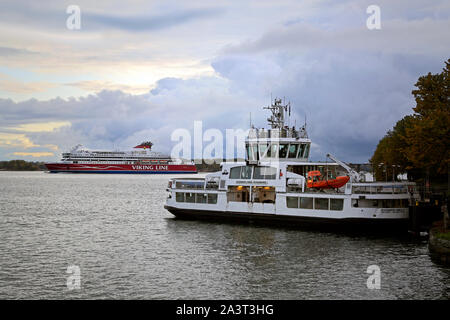 Suomenlinna ferry moored at Suomenlinna port with Viking XPRS ferry on the background arriving at Helsinki, Finland. October 8, 2019. Stock Photo