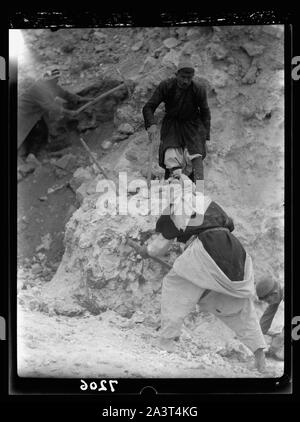 Tel Deweir (Lachish). Men clearing burnt line debris. Iron lance heads, arrowheads & fragments of scale armour found in this area due to attack, 588 B.C. Stock Photo