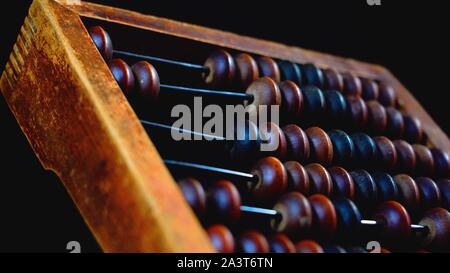 Vintage wooden abacus close up. Counting wooden knuckles. Part of the old end of the abacus on a dark background Stock Photo
