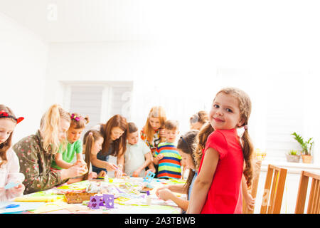 Kids making some paper crafts with teacher at workshop Stock Photo