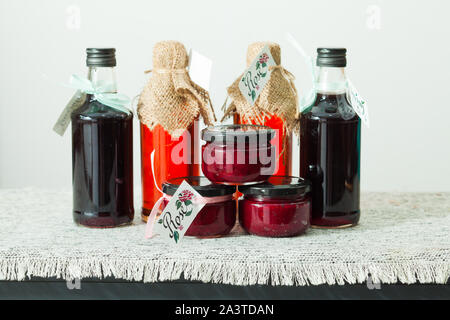 Homemade rose petal jam and berries syrup in bottles Stock Photo