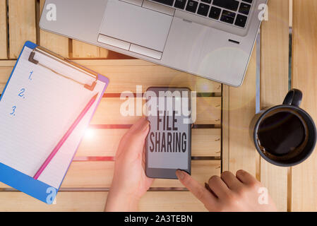 Conceptual hand writing showing File Sharing. Concept meaning transmit files from one computer to another over a network woman with laptop smartphone Stock Photo