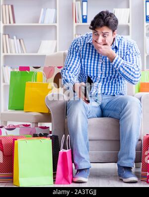 The young man after excessive shopping at home Stock Photo