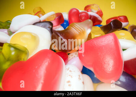 Pile of delicious colorful chewing candies background. Colourful sweets on yellow background Stock Photo