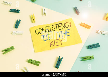 Handwriting text writing Consistency Is The Key. Conceptual photo full Dedication to a Task a habit forming process Colored clothespin paper empty rem Stock Photo