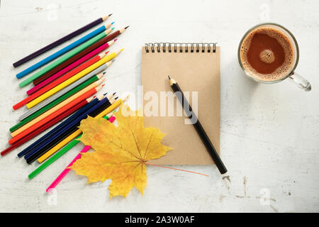 Colored pencils, dry leaves and paper. Frame for text. View from above. Autumn composition. Training Stock Photo