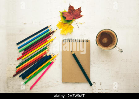 Colored pencils, dry leaves and paper. Frame for text. View from above. Autumn composition. Training Stock Photo