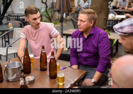 Group of men outdoors sitting and drinking beer Stock Photo