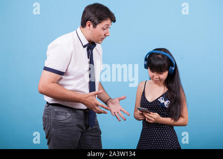 Asian girlfriend ignoring her caucasian boyfriend while he's trying to speak with her. Interracial couple. Stock Photo