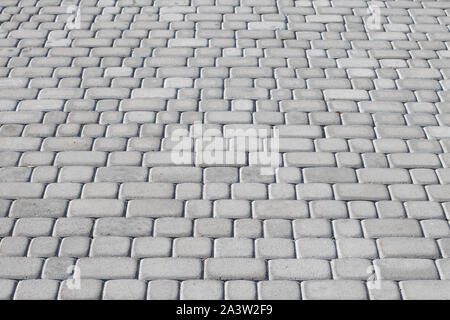 Pavement road of gray cobblestone. Urban paved walkway. Rock background. Natural backgrounds. Grey stone floor. Masonry texture. Stock Photo