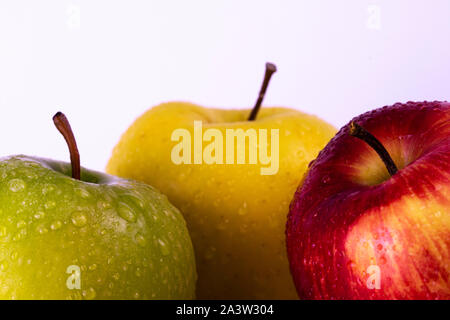 Three apples, multicolor fruits, bright background, water drops Stock Photo