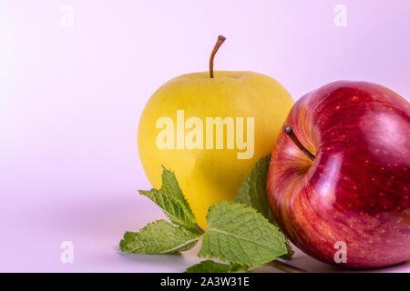 Red and yellow apples on bright background mint leaves, fresh apples Stock Photo