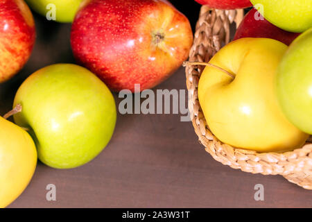 Multicolor apples, apples on bascket, wood background Stock Photo