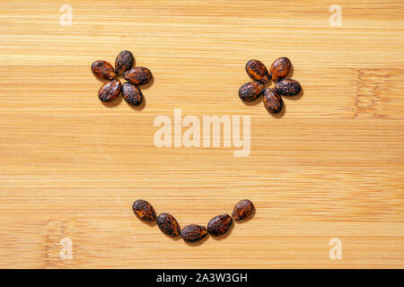 watermelon seeds on wooden background, smiley face Stock Photo