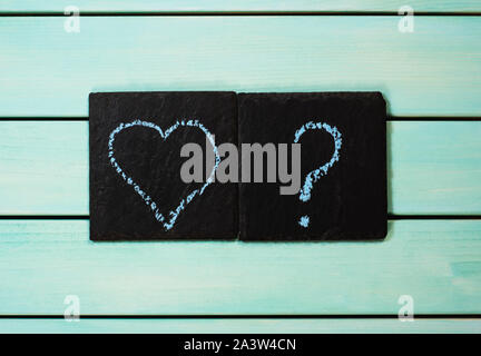Heart and question mark drawn with chalk, blue wooden background, love concept Stock Photo