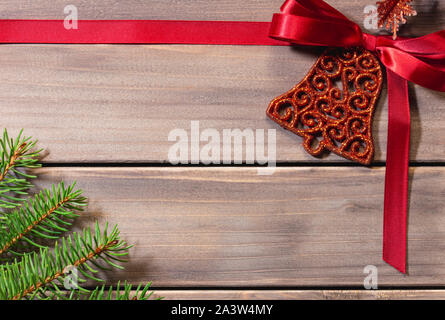 Christmas card with red bow and fir branch on wooden background, christmas frame with copy space Stock Photo