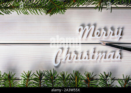 Christmas greeting card with copy space for text, Merry Christmas words on white wooden background Stock Photo
