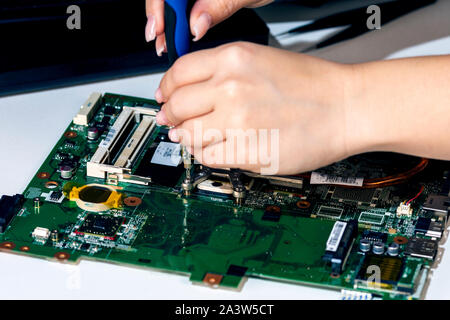 Woman engineer replace cpu from laptop motherboard Stock Photo