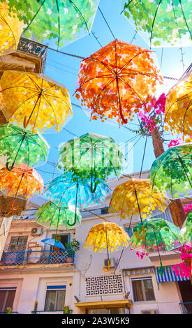 Street decorated with colorful umbrellas in Aegina town on summer sunny day, Aegina island, Greece Stock Photo