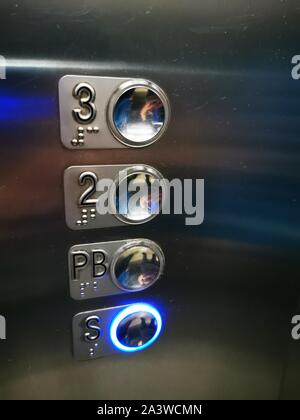 Forefinger pressing on button up in front of the elevator in office building Stock Photo