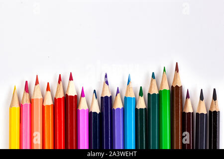 Set of colored pencils at the bottom of the frame in a row on a white background. Flat lay style. Stock Photo