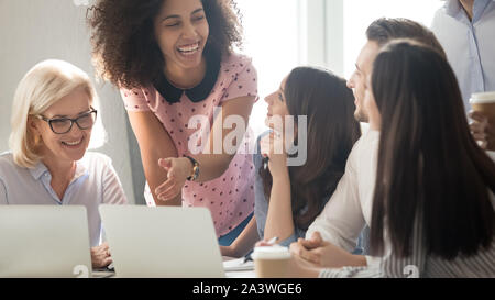 International company diverse members working together laughing having fun Stock Photo