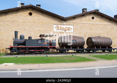Vintage locomotive and oak barrels in front of Bodegas Muga or winery, in Haro Station . District, Haro, La Rioja, Spain Stock Photo