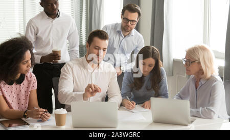 Company employees listening boss sitting at desk in boardroom Stock Photo