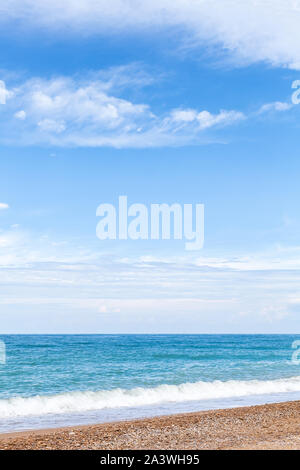 Empty beach, vertical background photo. Natural summer landscape, sandy sea coast under cloudy blue sky Stock Photo