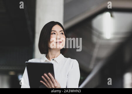 Japanese businesswoman using digital tablet in a corporate office Stock Photo