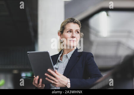 Senior female business executive using digital tablet in a corporate office Stock Photo