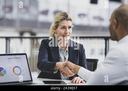 Senior female business executive shaking hands Stock Photo