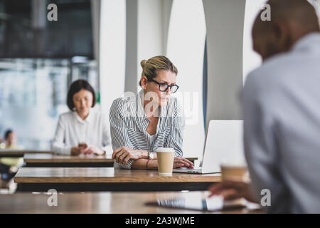 Businesswoman in a cafÃ© using a laptop Stock Photo