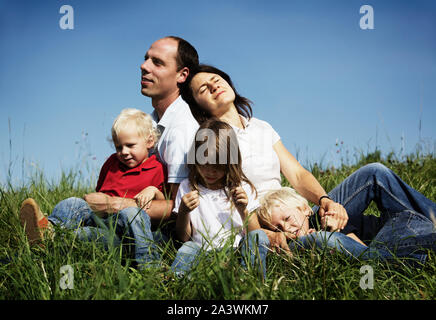 Family resting in meadow Stock Photo