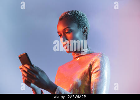 Creative shot of african american young adult female using smartphone Stock Photo